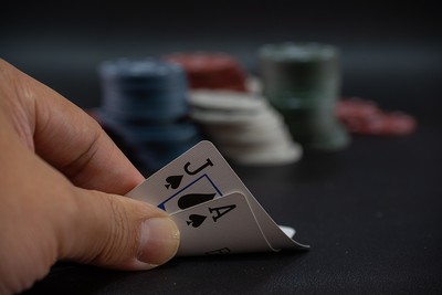 Gambler Looking at Blackjack Cards on Table