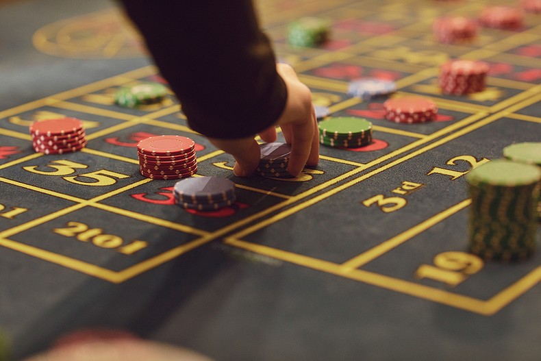 Man Placing Chips on Roulette Table