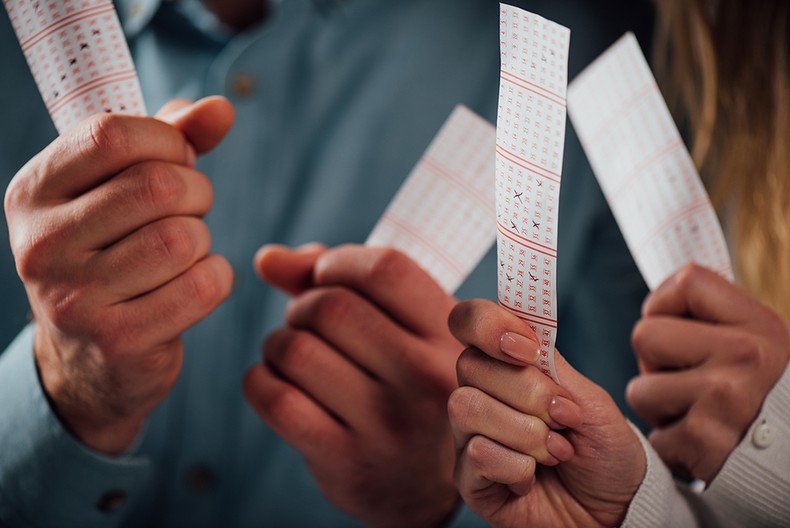 Man and Woman Holding Lottery Tickets