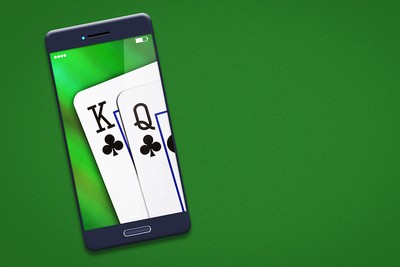 Playing Cards on Smartphone Against Green Background