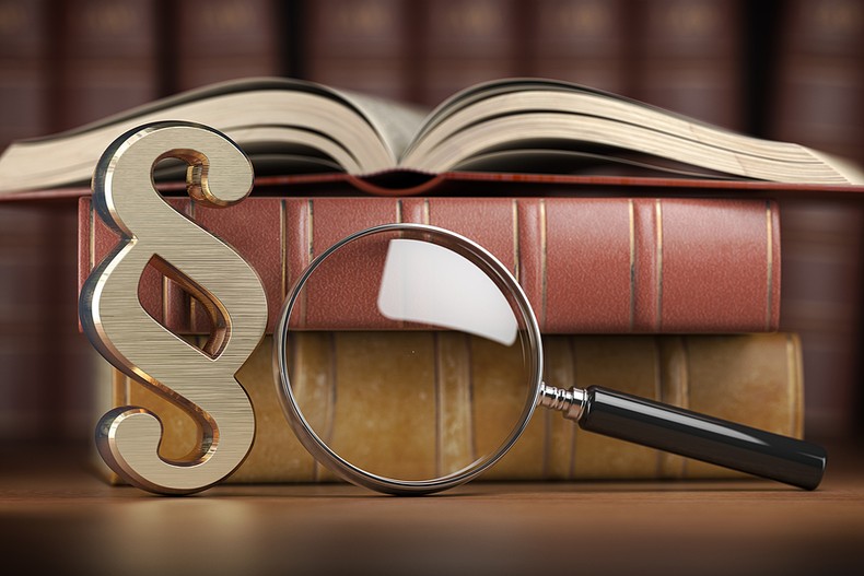Section Sign with Legal Books and Magnifying Glass