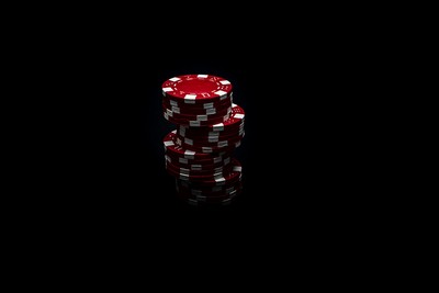 Stack of Red Poker Chips Against Black Background